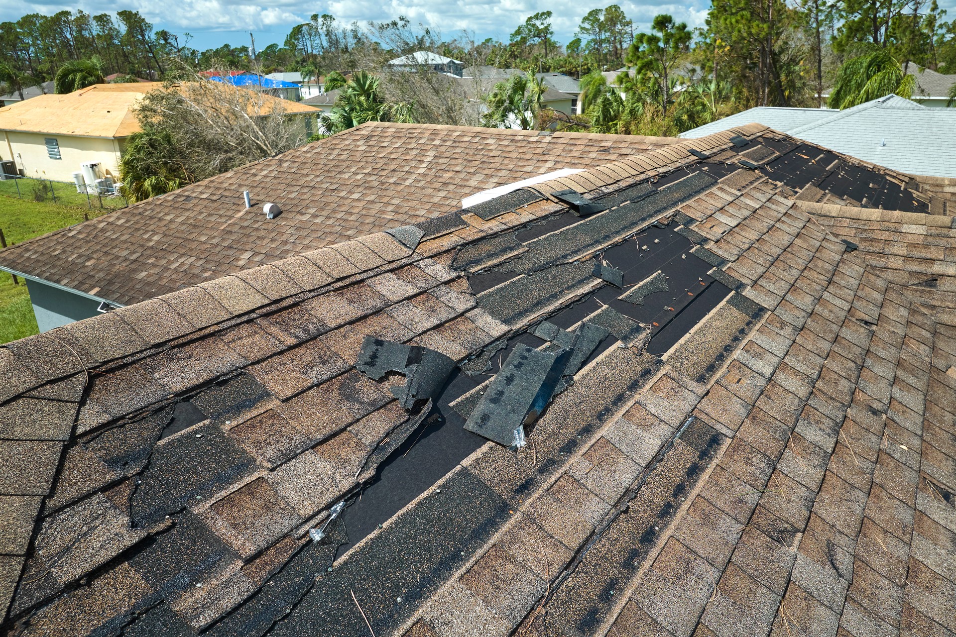 Le toit d’une maison a été endommagé par le vent avec des bardeaux d’asphalte manquants après le passage de l’ouragan Idalia en Floride. Réparation d’un concept de toiture de maison